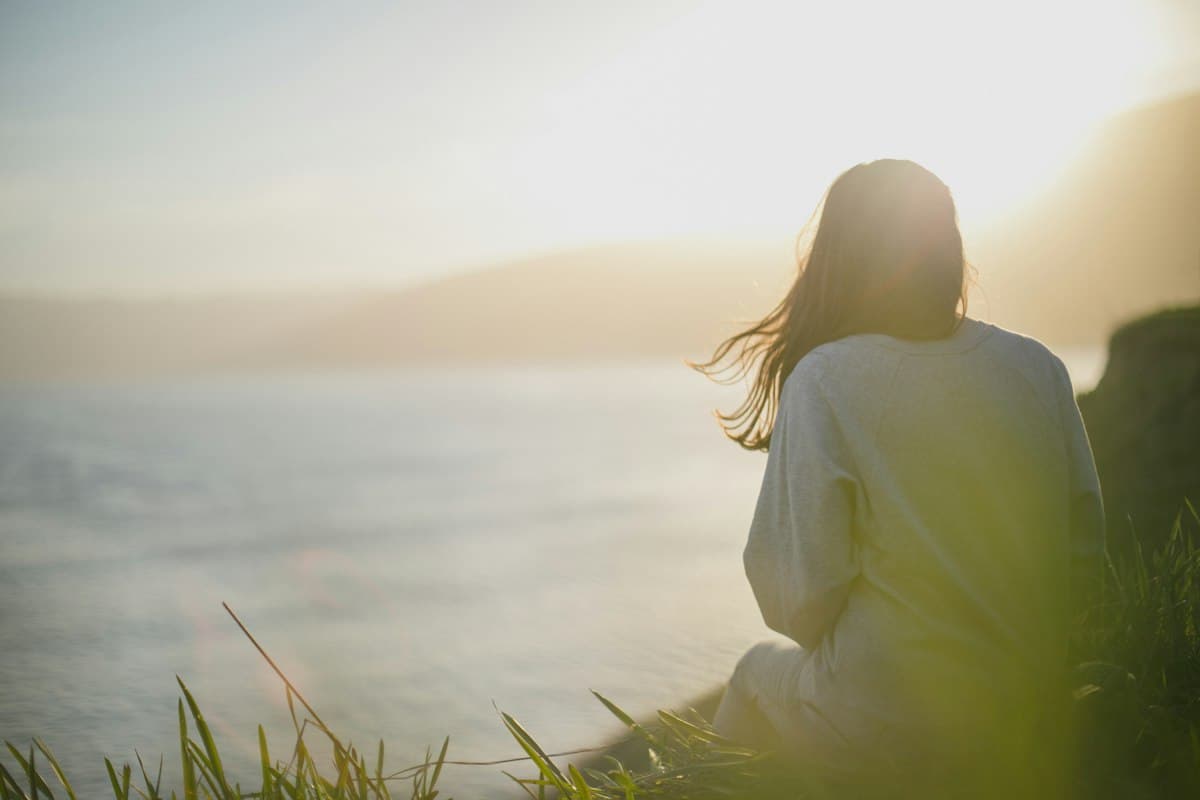 Femme assise face à la mer, un moment de pause pendant l'attente d'une écho de contrôle