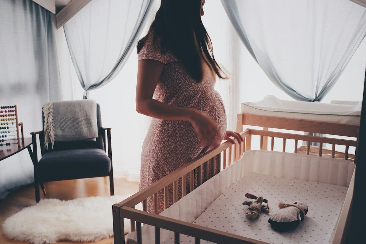 Femme enceinte sereine dans la chambre de bébé, malgré un placenta bas inséré